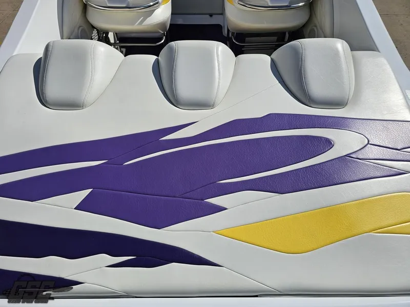 Slide: The Image of 2004 Baja 25 Outlaw boat interior with purple and yellow design on white seats. - 37