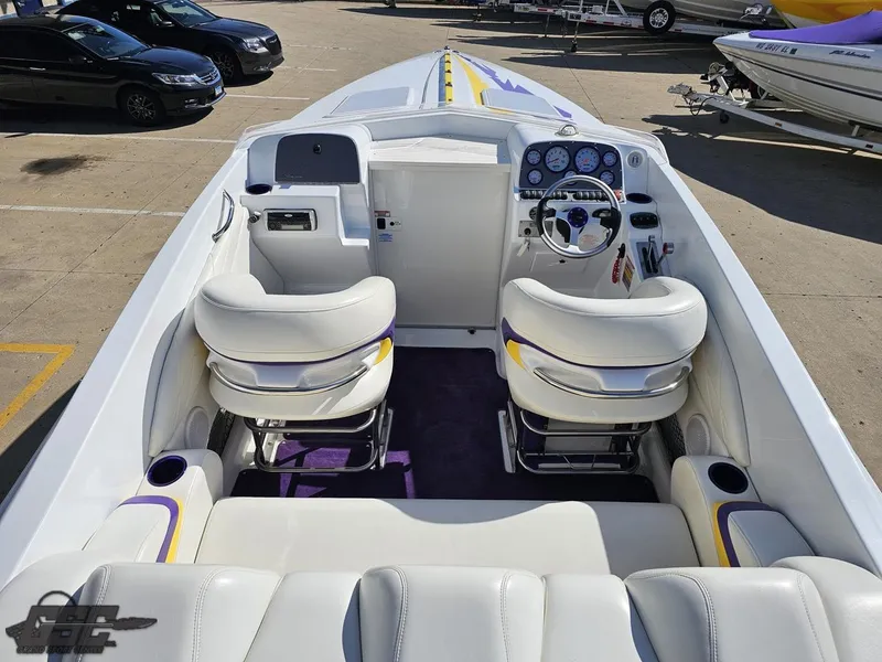 Slide: The Image of 2004 Baja 25 Outlaw boat interior with white seating and dashboard controls. - 42