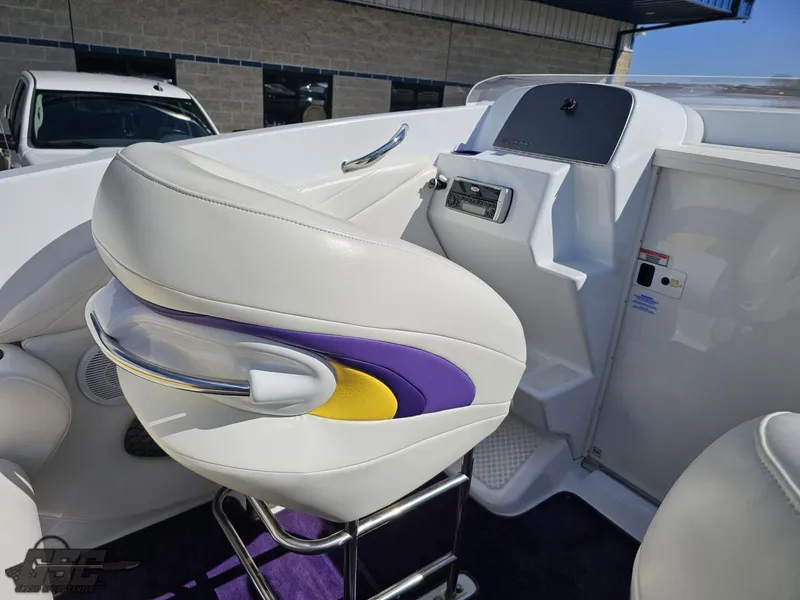 Slide: The Image of 2004 Baja 25 Outlaw boat interior with white and purple seating, modern dashboard. - 48