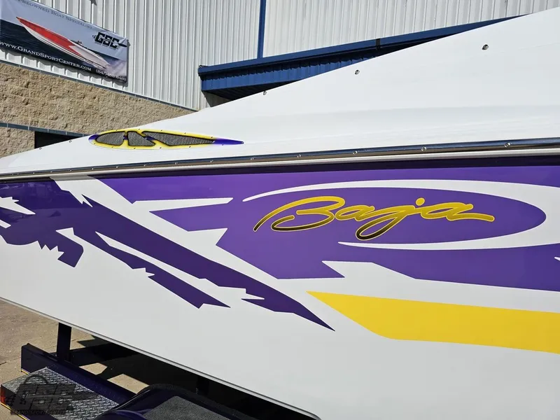 Slide: The Image of 2004 Baja 25 Outlaw boat with vibrant purple and yellow graphics. - 9