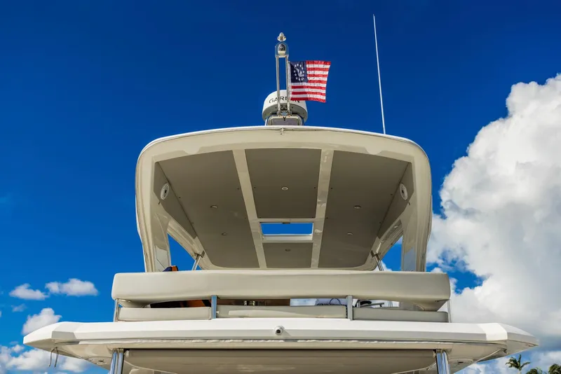 Slide: The Image of 2018 Absolute 52 FLY yacht against blue sky with American flag. - 11