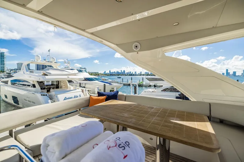 Slide: The Image of Luxurious 2018 Absolute 52 FLY yacht with elegant seating and scenic marina view. - 13