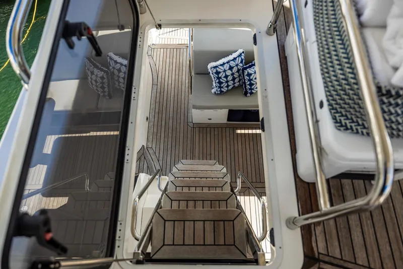 Slide: The Image of Staircase view on 2018 Absolute 52 FLY yacht with wooden deck and patterned cushions. - 18