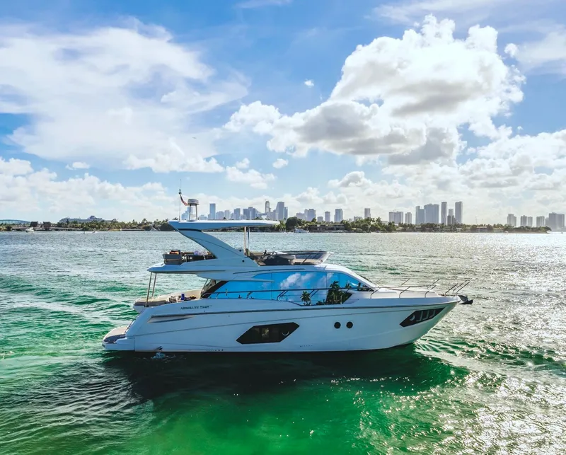 Slide: The Image of Luxurious 2018 Absolute 52 FLY yacht cruising on a sunny day with city skyline backdrop. - 2