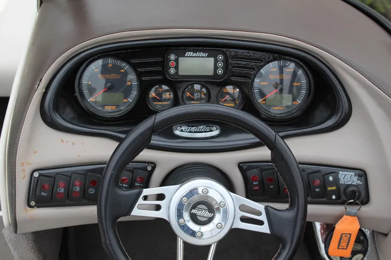 Slide: The Image of Dashboard of a 2006 Malibu Sunscape 21 LSV boat with steering wheel and gauges. - 12