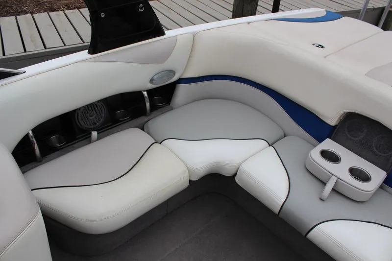 Slide: The Image of 2006 Malibu Sunscape 21 LSV boat interior with white seating and cup holders. - 8