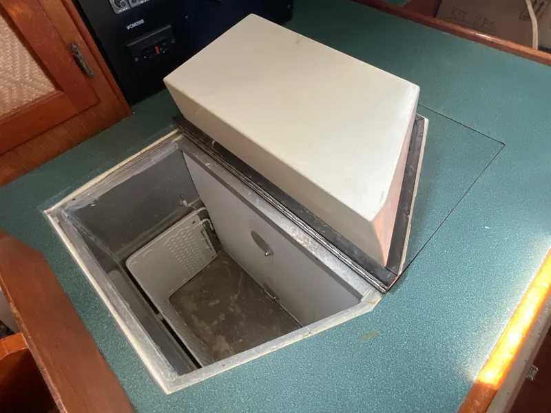 Slide: The Image of 1984 Clearwater CUTTER boat interior with open storage compartment on green countertop. - 12