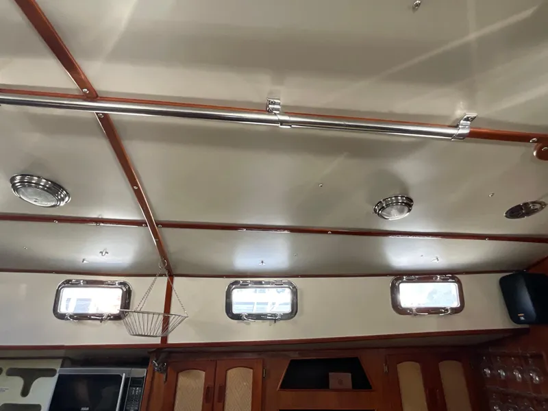 Slide: The Image of Interior of 1984 Clearwater Cutter boat with wooden accents and porthole windows. - 13