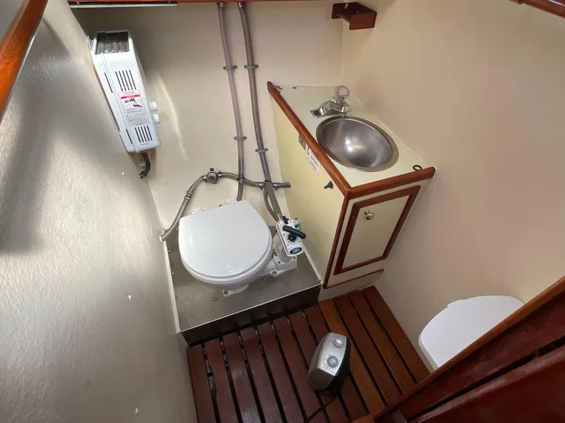 Slide: The Image of 1984 Clearwater CUTTER boat bathroom with toilet, sink, and wooden floor. - 15