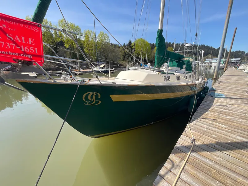 Slide: The Image of 1984 Clearwater Cutter sailboat docked, green hull, for sale sign visible. - 23
