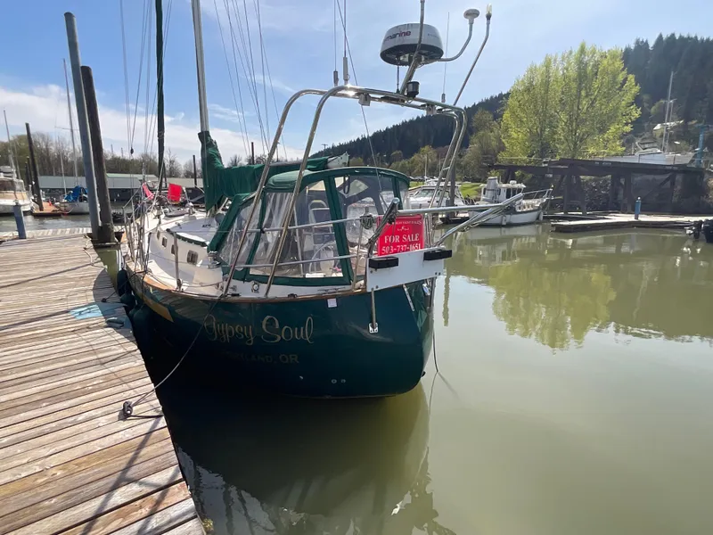 Slide: The Image of 1984 Clearwater Cutter sailboat docked, "For Sale" sign, calm marina setting. - 24