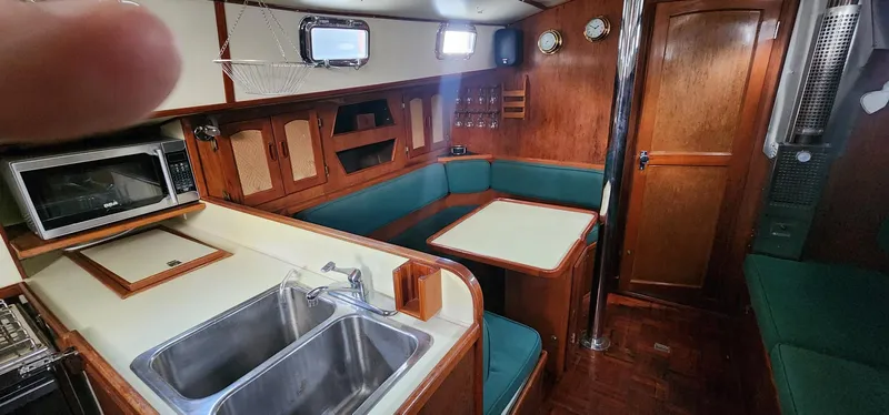 Slide: The Image of 1984 Clearwater Cutter yacht interior with kitchen, dining area, and wooden cabinetry. - 4