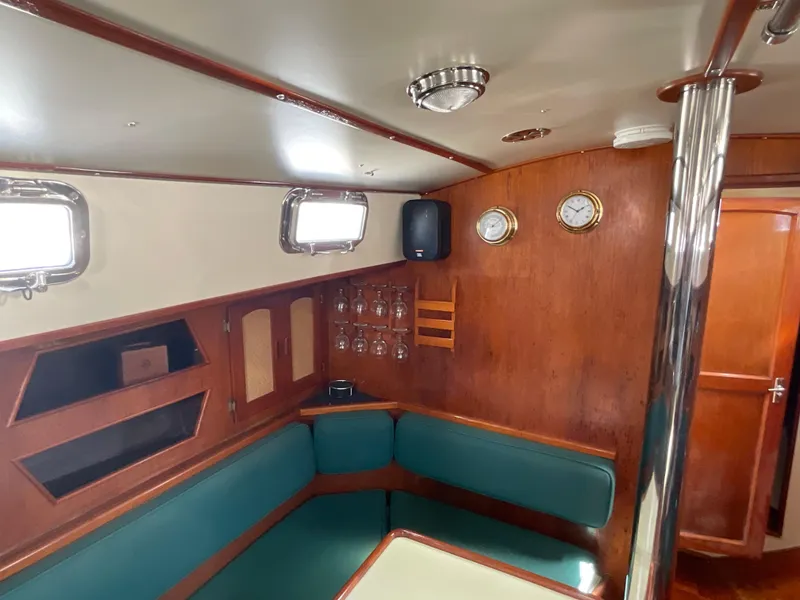 Slide: The Image of 1984 Clearwater Cutter yacht interior with wood paneling, green seating, and nautical decor. - 5