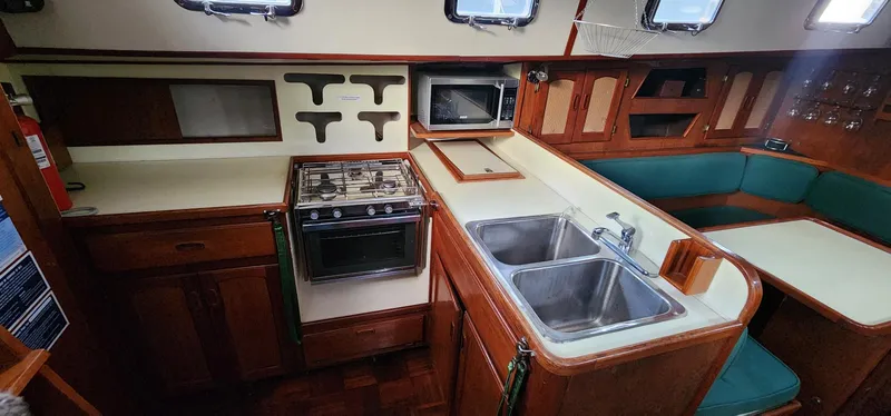 Slide: The Image of 1984 Clearwater Cutter yacht interior with kitchen, stove, sink, and seating area. - 8
