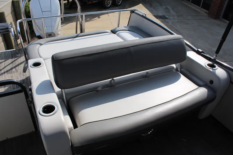 Slide: The Image of 2023 Tahoe Pontoon Cascade Platinum Versatile Rear Bench, gray seating, cup holders, outdoor setting. - 7