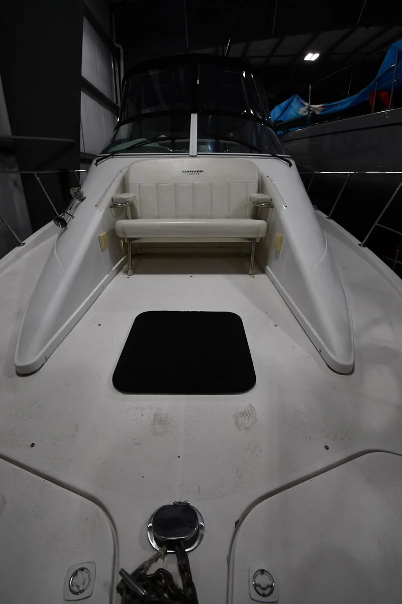 Slide: The Image of 2000 Carver 350 Mariner boat deck with seating and hatch in a dimly lit setting. - 2