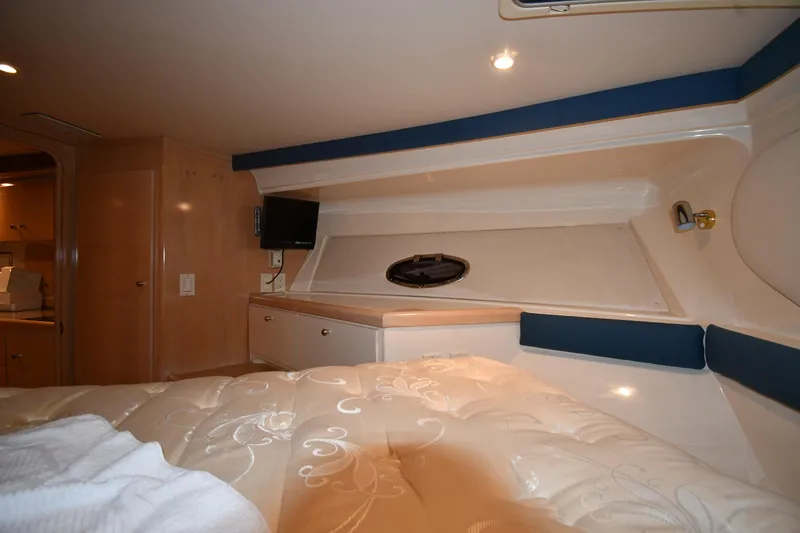 Slide: The Image of Interior cabin of 2000 Carver 350 Mariner yacht, featuring a cozy bed and small TV. - 31