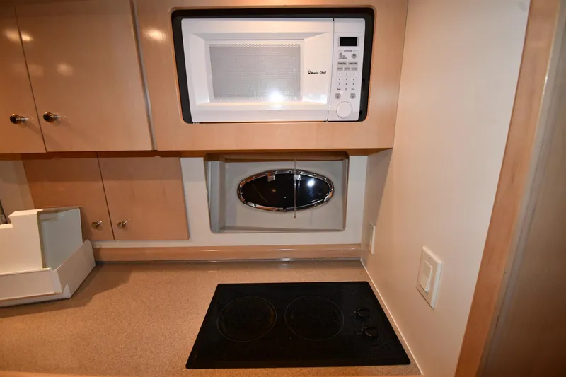 Slide: The Image of Compact kitchen area in a 2000 Carver 350 Mariner with microwave and stovetop. - 48