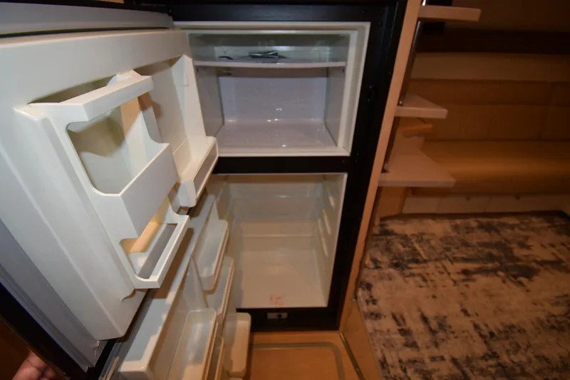 Slide: The Image of Open refrigerator inside a 2000 Carver 350 Mariner yacht, showing empty shelves and compartments. - 49