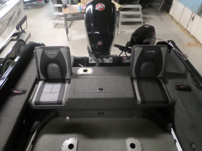 Slide: The Image of 2020 Lund IMPACT 1775 XS boat interior with dual seats and motor in a garage. - 4