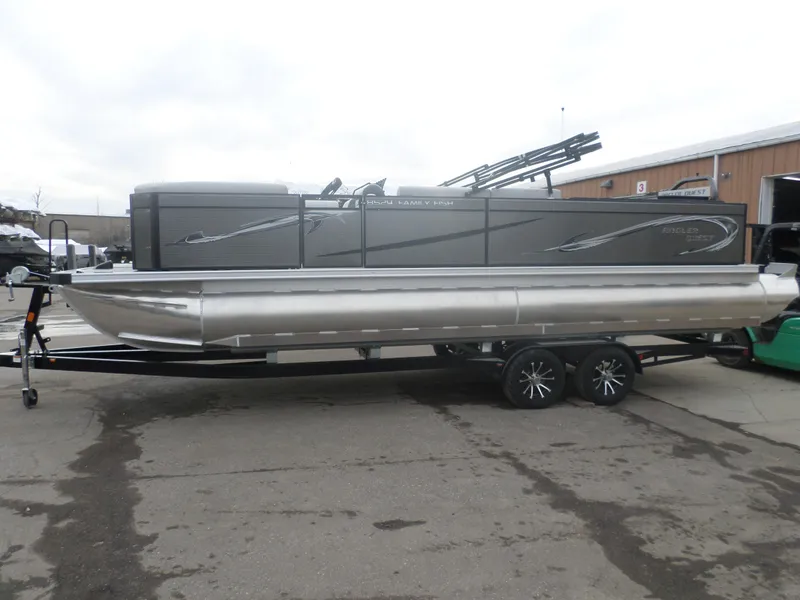 Slide: The Image of 2025 Angler Quest 8524 Family Fish pontoon boat on trailer, parked outdoors. - 1