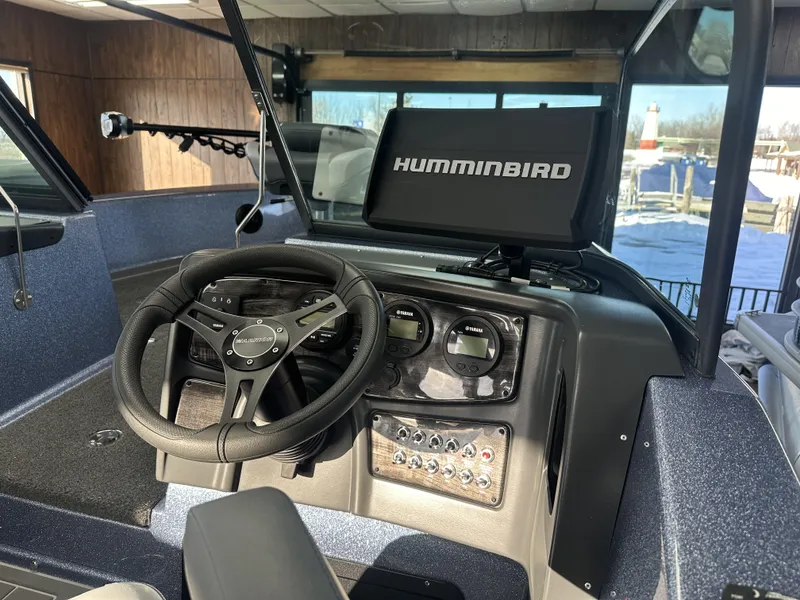 Slide: The Image of Interior of 2025 Warrior 208 DC boat with steering wheel and Humminbird display. - 3