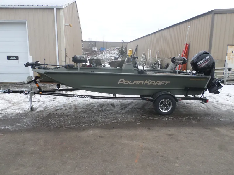 Slide: The Image of 2023 Polar Kraft Sportsman 1754 SC boat on trailer, parked outside industrial building. - 1