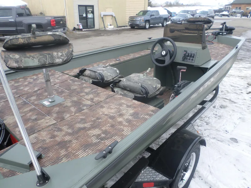 Slide: The Image of 2023 Polar Kraft Sportsman 1754 SC boat with camouflage seats and steering wheel, parked outdoors. - 3