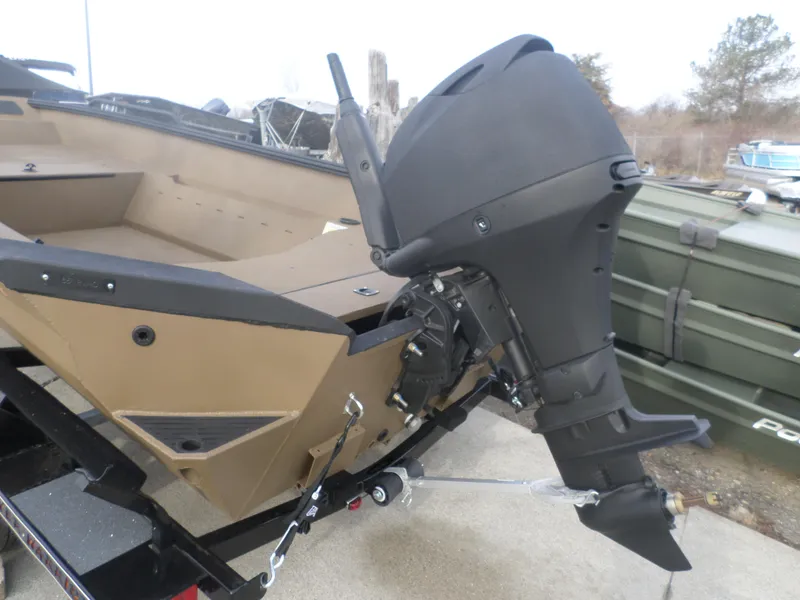 Slide: The Image of 2025 Excel 1651 River Warrior boat with powerful outboard motor, parked on a trailer. - 4