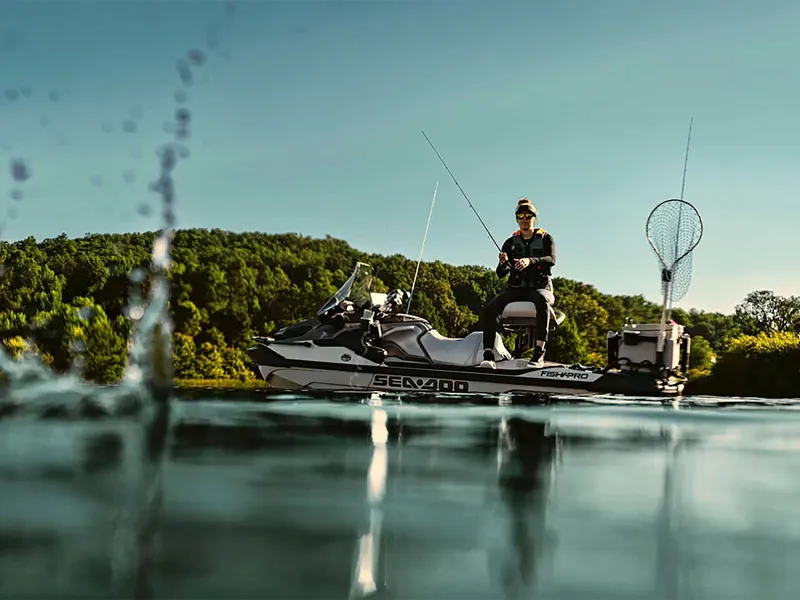 Slide: The Image of 2025 Sea-Doo FishPro Apex 300 on a serene lake, with a person fishing. - 10