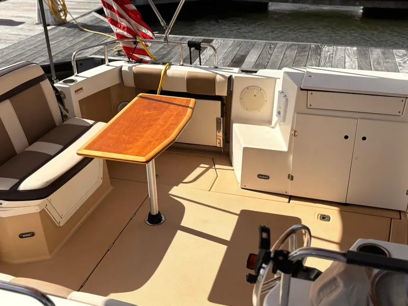 Slide: The Image of 2016 Cutwater 28 LE boat interior with seating, table, and storage compartments. - 14