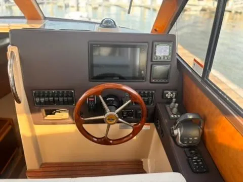Slide: The Image of Helm of 2016 Cutwater 28 LE boat with wooden steering wheel and navigation controls. - 21