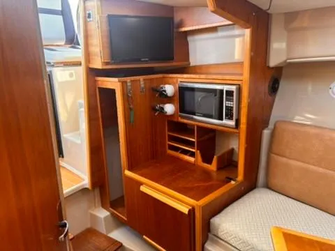 Slide: The Image of Interior of 2016 Cutwater 28 LE boat with TV, microwave, and seating area. - 22