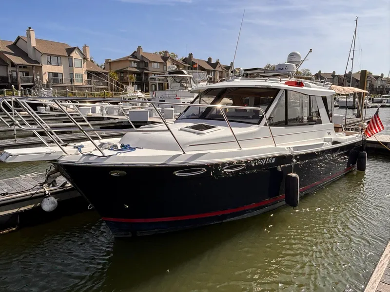 Slide: The Image of 2016 Cutwater 28 LE boat docked in a marina with waterfront homes in the background. - 3