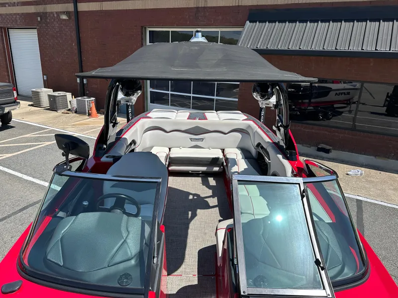 Slide: The Image of 2015 Supra SG400-550 boat with open cockpit and sunshade, parked outdoors. - 12