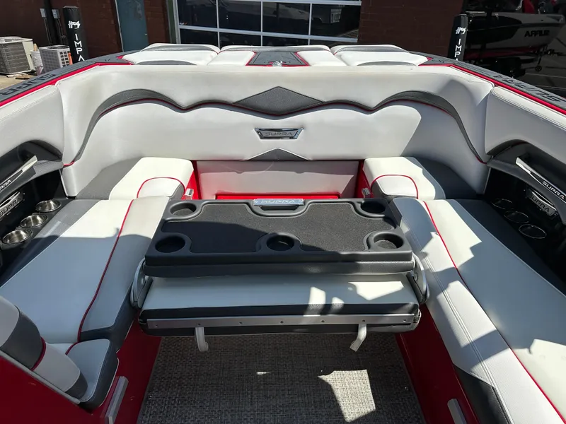 Slide: The Image of 2015 Supra SG400-550 boat interior with white and red seating, cup holders, and storage. - 14