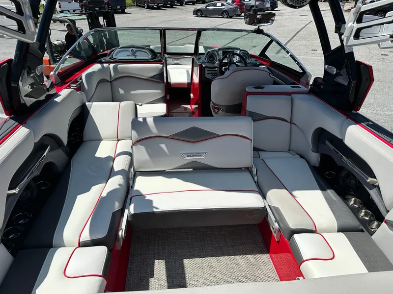 Slide: The Image of 2015 Supra SG400-550 boat interior with red and white seating, spacious layout, and modern dashboard. - 15