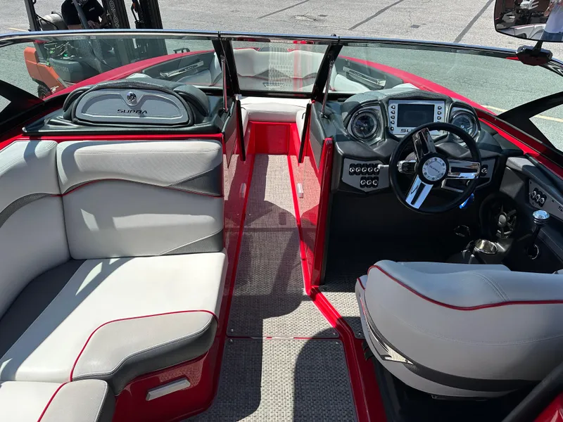 Slide: The Image of 2015 Supra SG400-550 boat interior with red and white seating, modern dashboard, and steering wheel. - 8