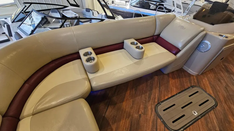 Slide: The Image of 2017 Manitou 25 Aurora LE boat interior with beige seating and cup holders. - 15