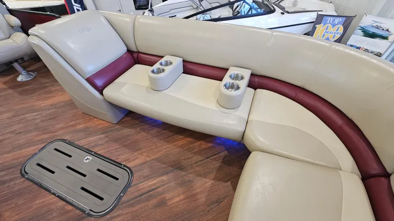 Slide: The Image of Luxurious seating in 2017 Manitou 25 Aurora LE pontoon boat with cup holders and wood flooring. - 16
