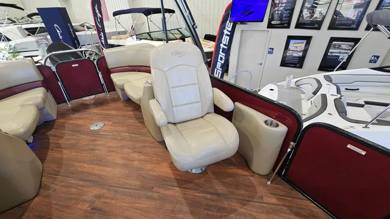 Slide: The Image of 2017 Manitou 25 Aurora LE boat interior with beige seating and wood flooring. - 17