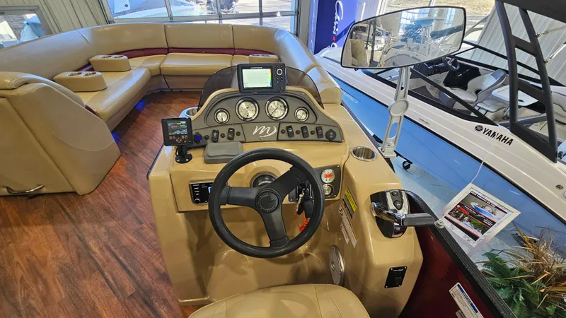 Slide: The Image of 2017 Manitou 25 Aurora LE boat interior with steering console and seating area. - 19