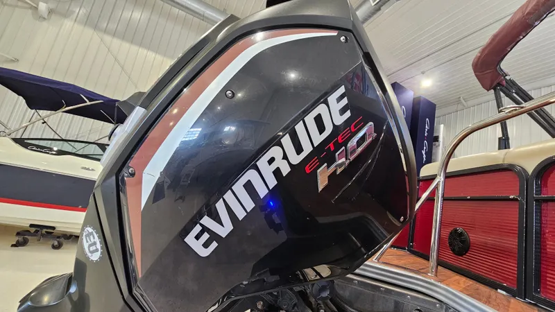 Slide: The Image of Evinrude E-TEC 150 engine on 2017 Manitou 25 Aurora LE boat in showroom. - 38