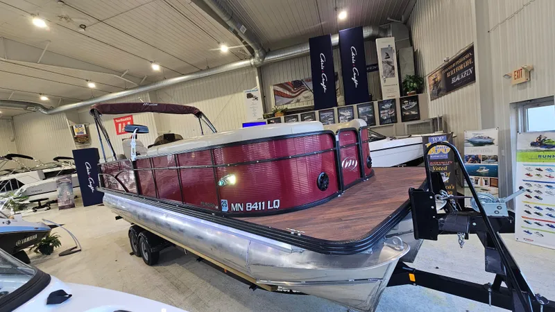 Slide: The Image of 2017 Manitou 25 Aurora LE pontoon boat displayed indoors on a trailer. - 4