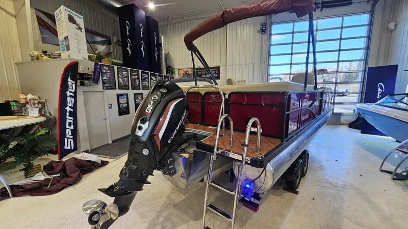Slide: The Image of 2017 Manitou 25 Aurora LE pontoon boat in showroom with outboard motor and ladder. - 7