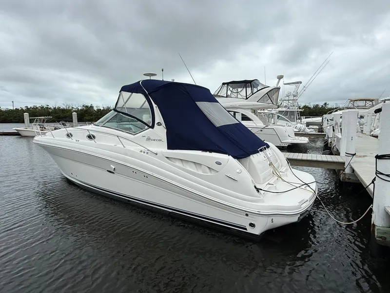 Slide: The Image of 2005 Sea Ray 340 Sundancer boat docked in a marina under cloudy skies. - 2