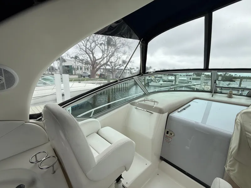Slide: The Image of 2005 Sea Ray 340 Sundancer cockpit with white seating and marina view. - 31