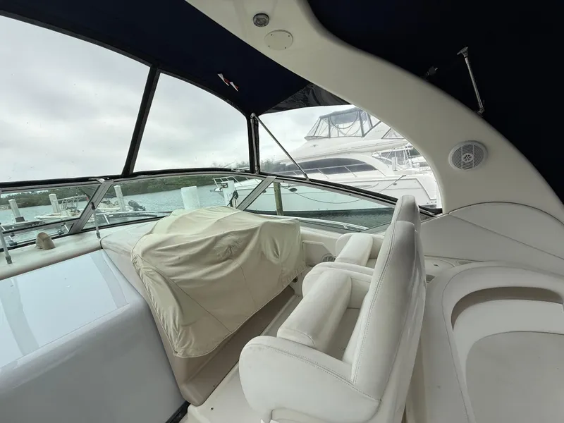 Slide: The Image of 2005 Sea Ray 340 Sundancer cockpit with covered controls and white seating. - 32