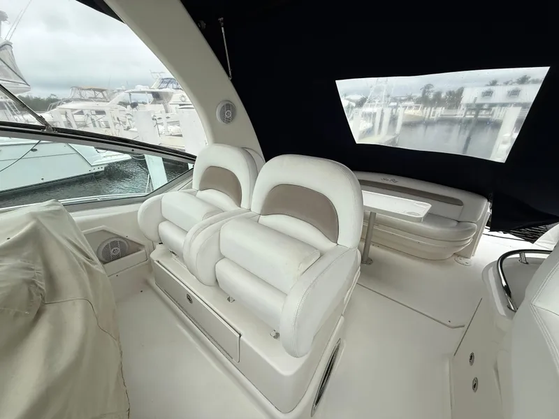 Slide: The Image of 2005 Sea Ray 340 Sundancer interior with white seating and marina view. - 33