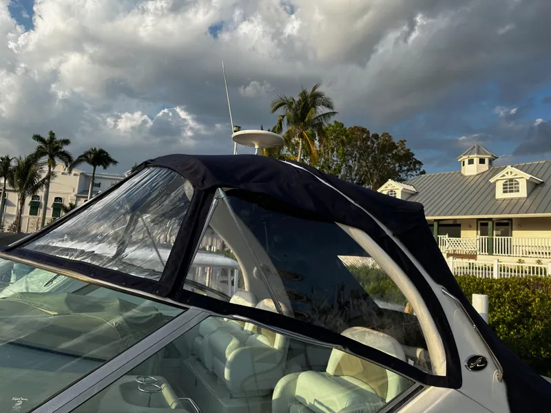 Slide: The Image of 2005 Sea Ray 340 Sundancer boat with canopy, set against a tropical backdrop. - 7